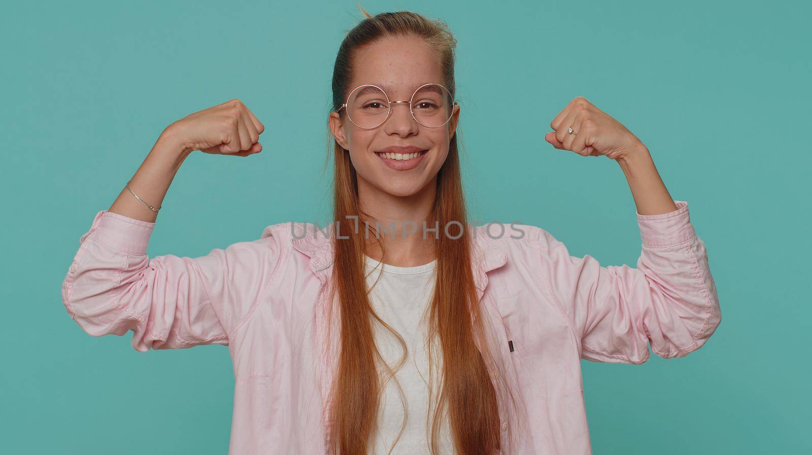 I am strong and independent. Pretty teenager young girl showing biceps and looking confident, feeling power strength to fight for rights, energy to gain success win. Fit sporty student child kid