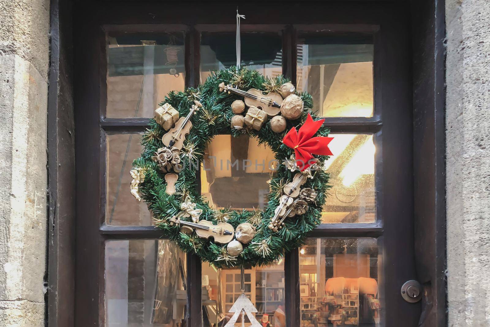 Christmas wreath with small miniatures on a glass door