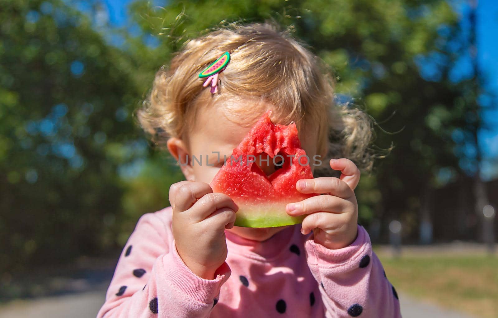 The child eats watermelon in summer. Selective focus. Kid.