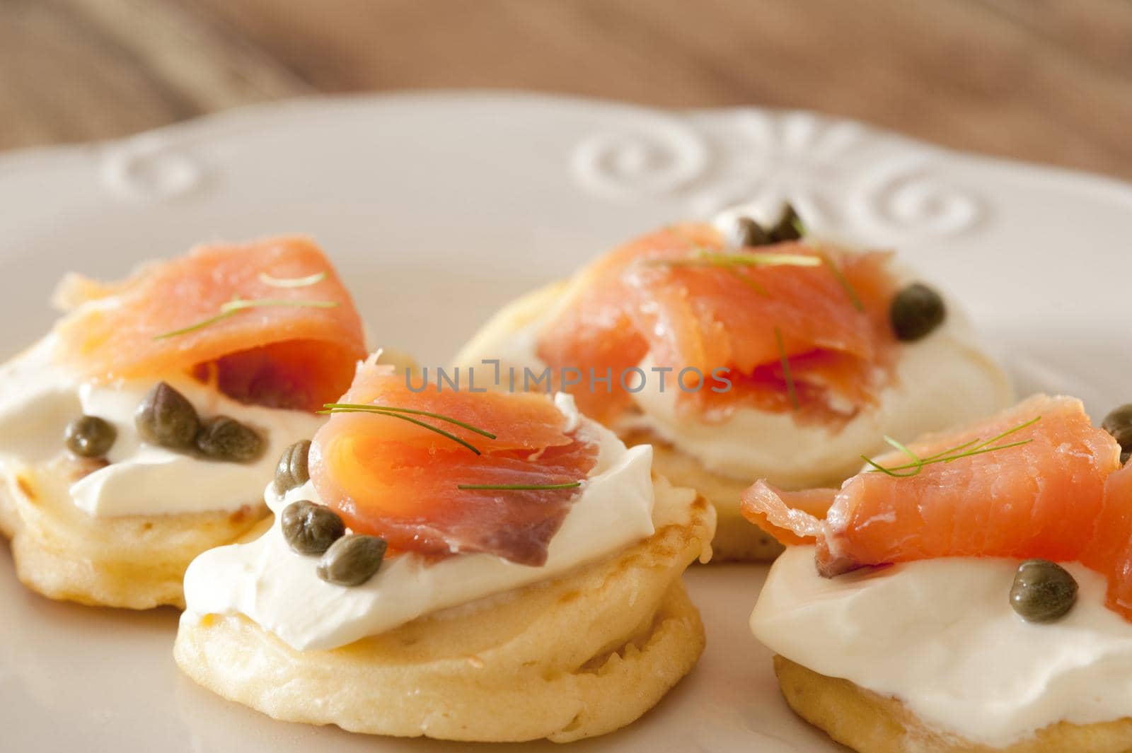a plate of smoked salmon and cream cheese blini canapes