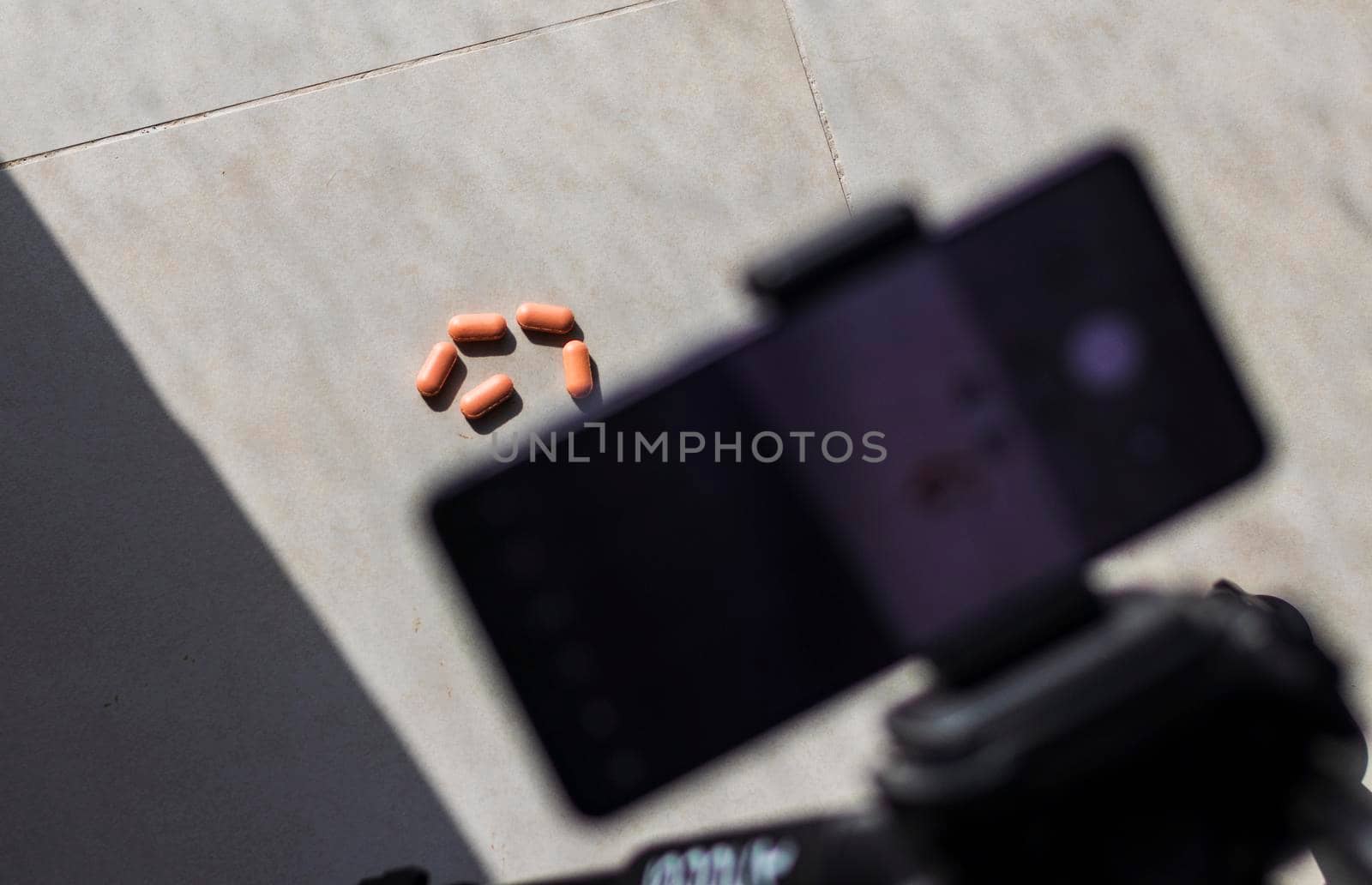 Close up shot of a phone on tripod capturing medicine on the surface. Technology by pazemin