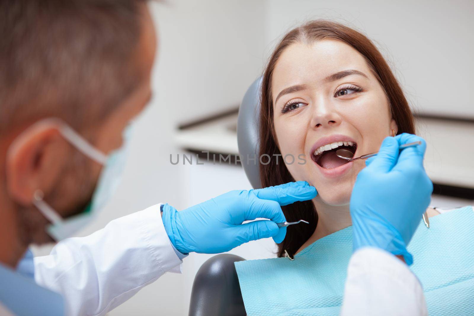 Beautiful young woman visiting dentist for medical checkup by MAD_Production