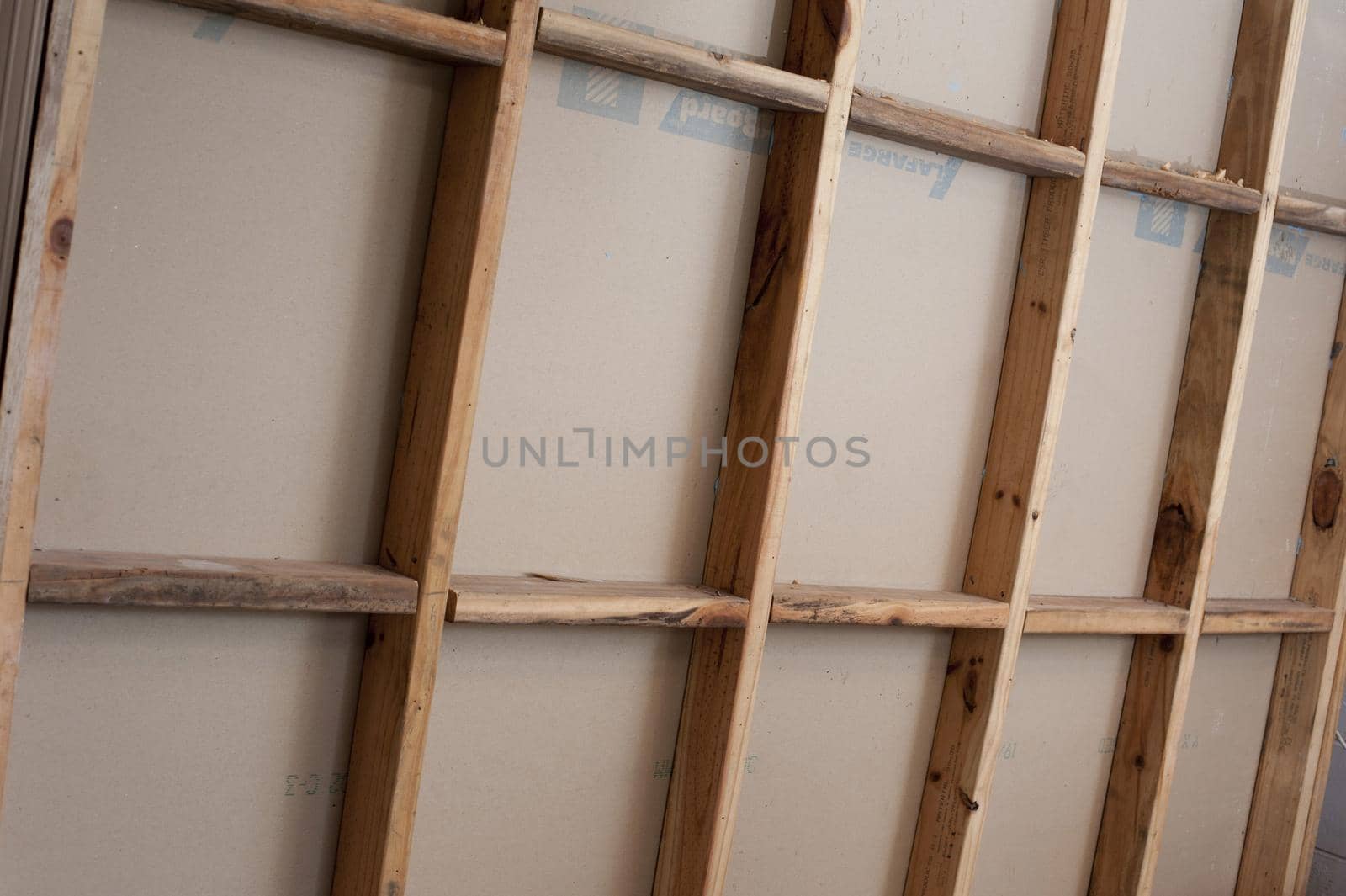 Open stud wall of wooden frame house under construction, viewed in full frame from the side