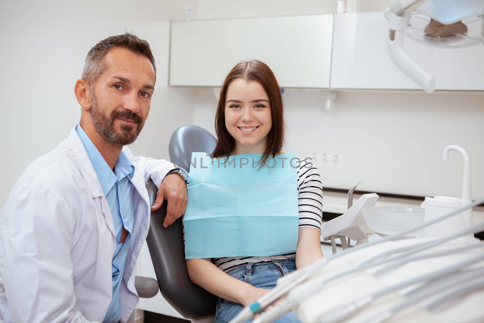 Mature male dentist working at his clinic by MAD_Production