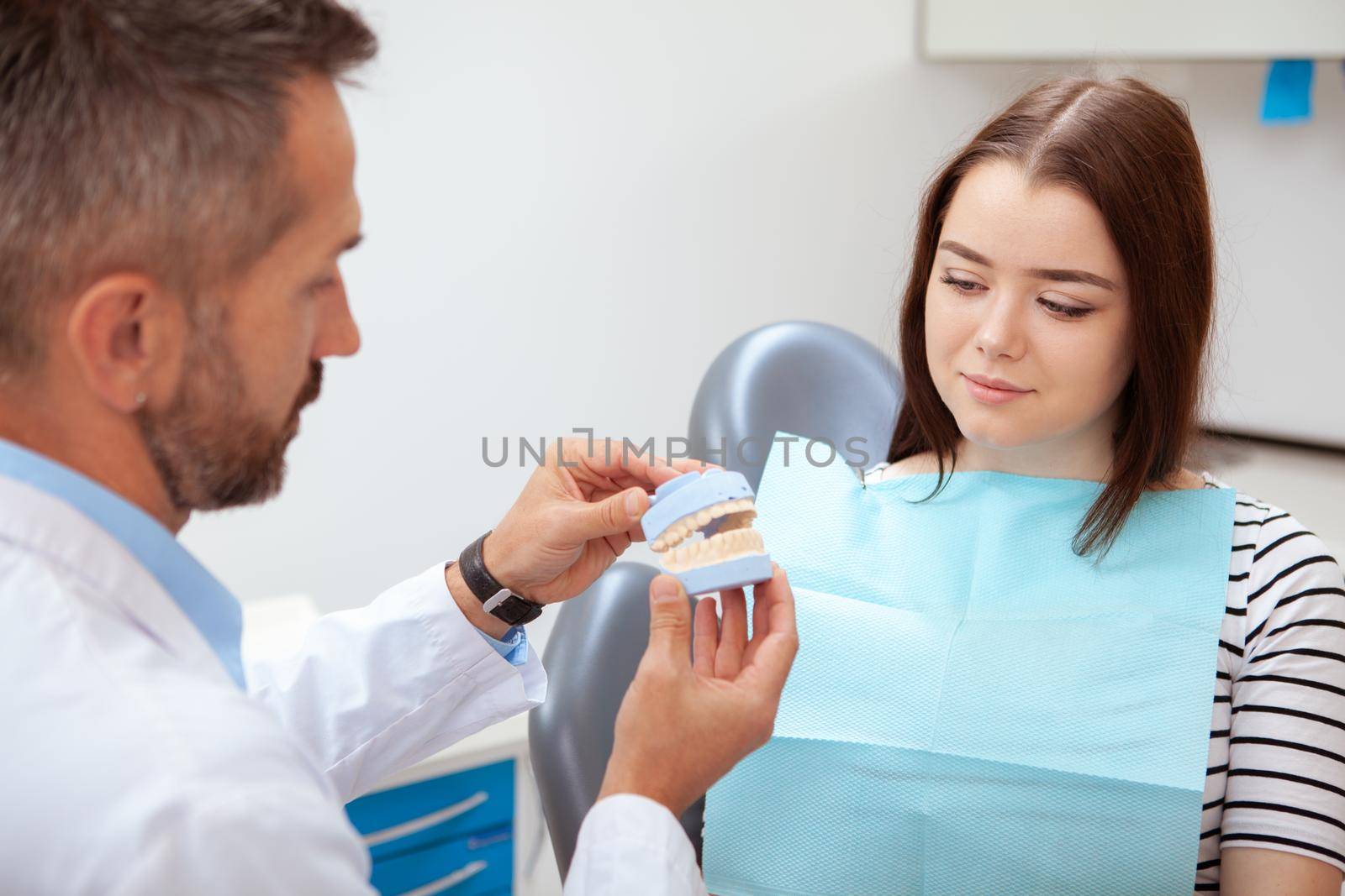 Beautiful young woman visiting dentist for medical checkup by MAD_Production