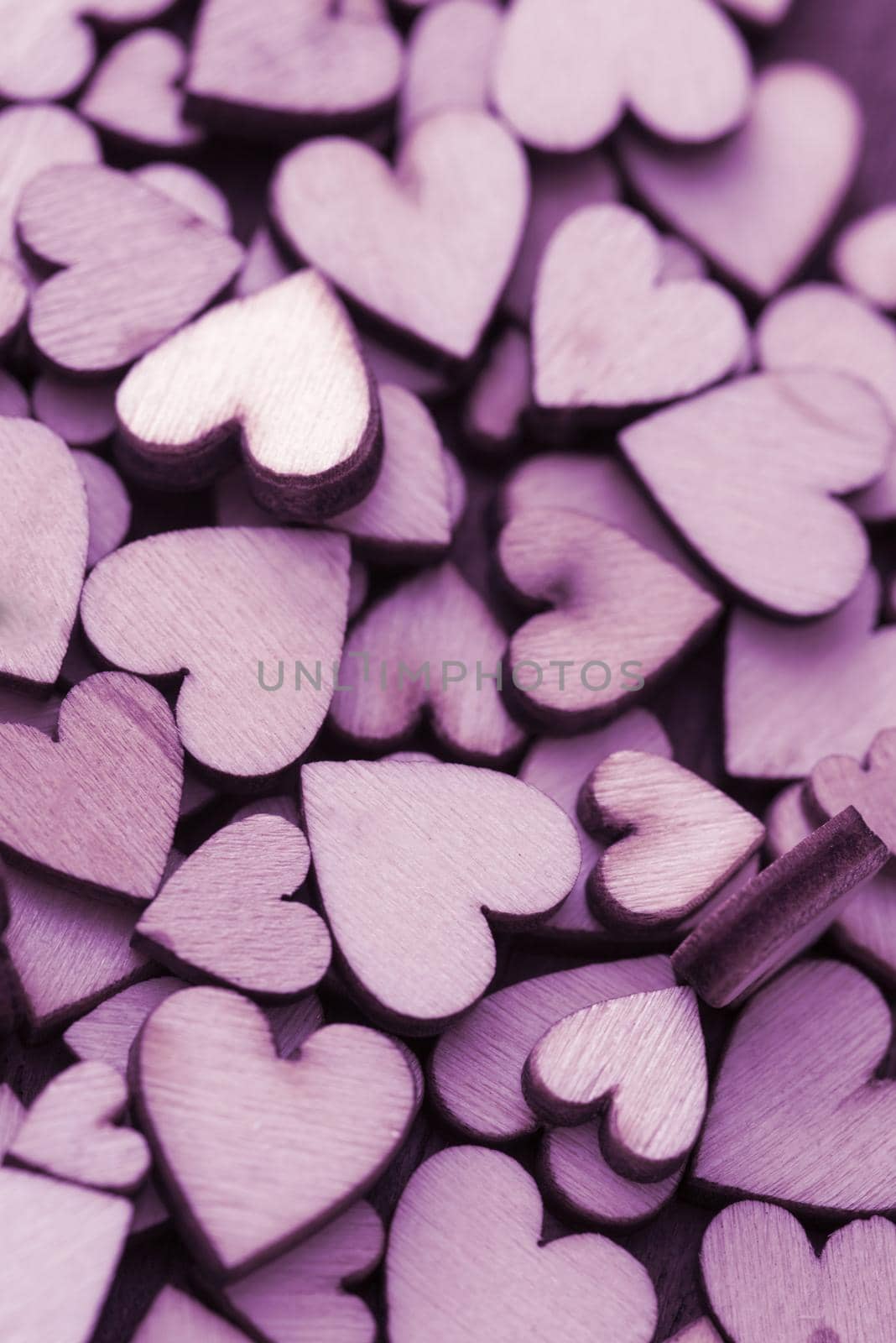 Pile of small purple craft wooden hearts cut from plywood, full frame background concept