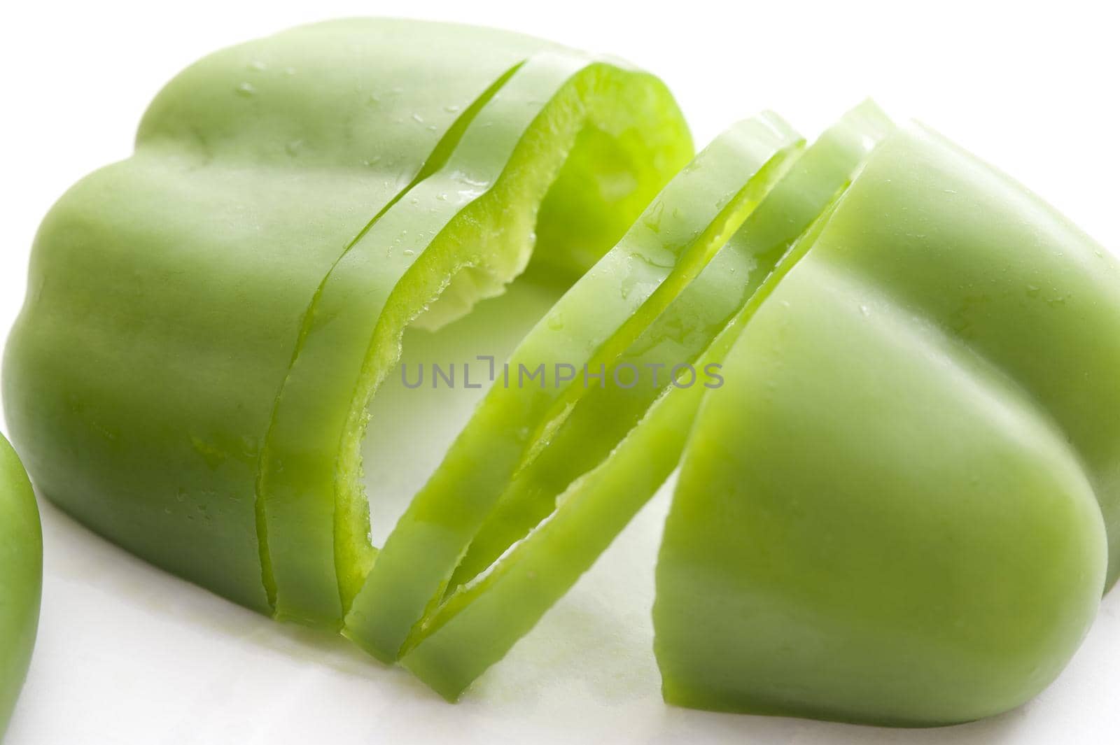 Halved and sliced fresh green sweet bell pepper or capsicum for use as an ingredient in a salad or for cooking