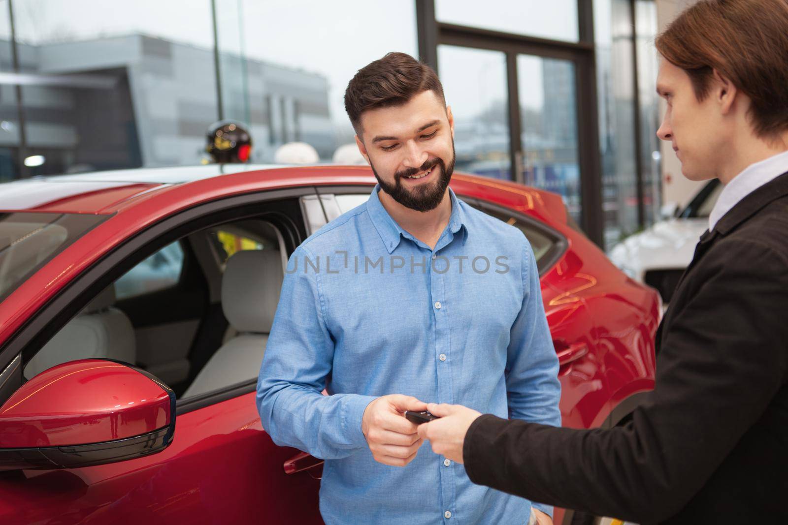 Car dealer selling new autos at the dealership by MAD_Production