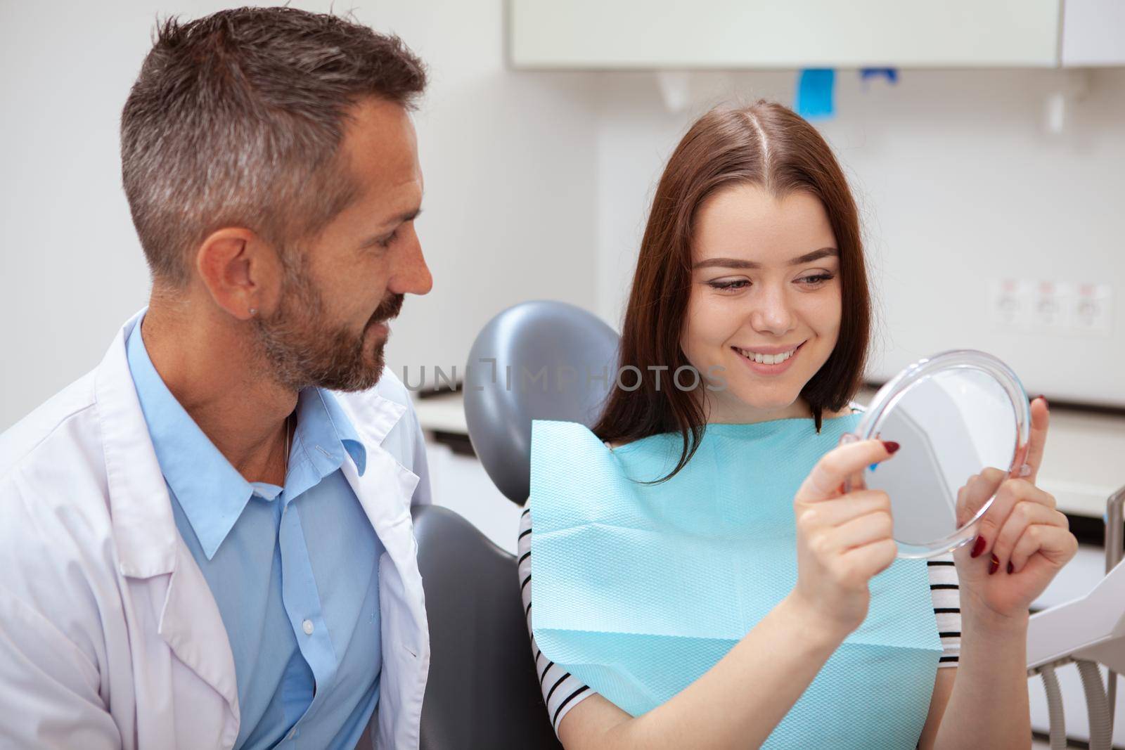 Mature male dentist working at his clinic by MAD_Production