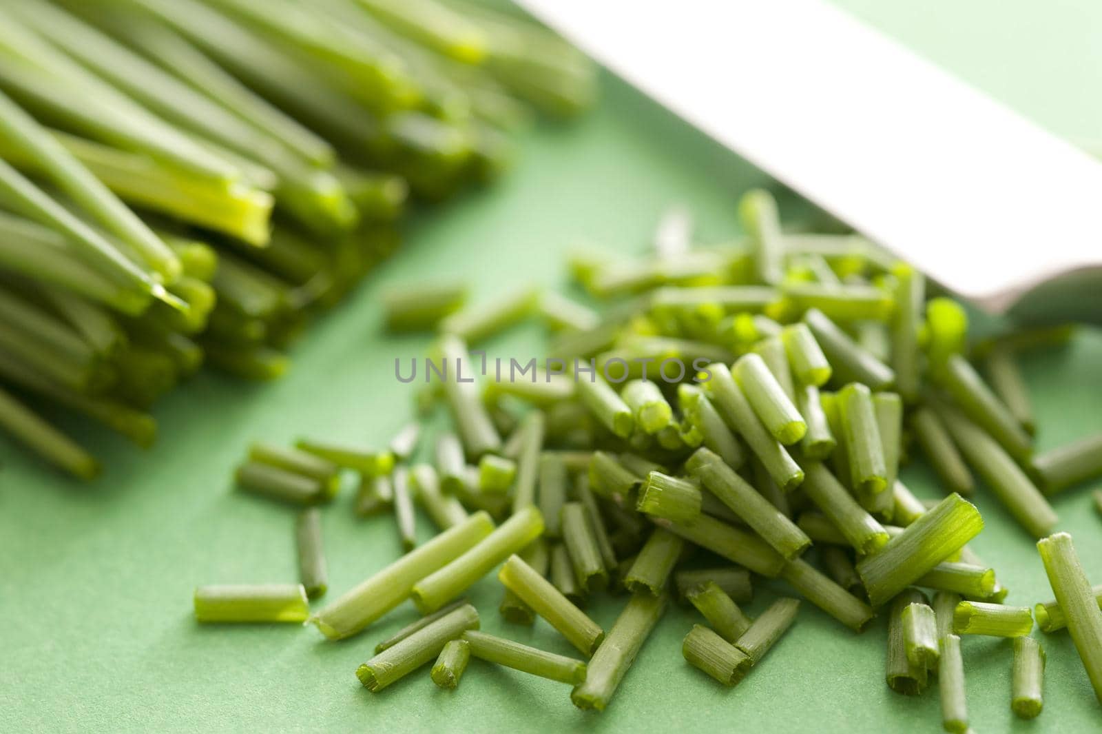 Pile of fresh chopped green chives on a chopping board ready for use as garnish or salad ingredient