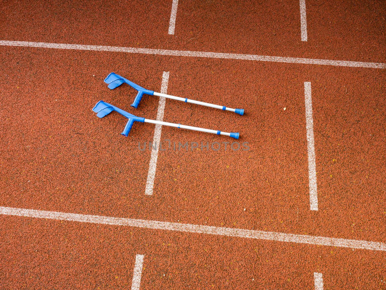 Forearm crutches on red running track on stadium. Run lines by rdonar2