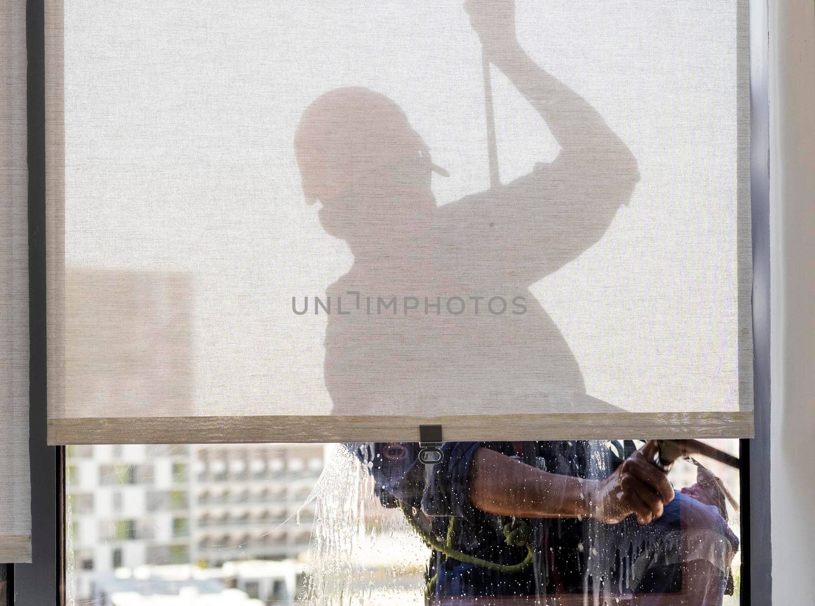 Silhouette of a rope access glass cleaner working at heights. Industrial by pazemin