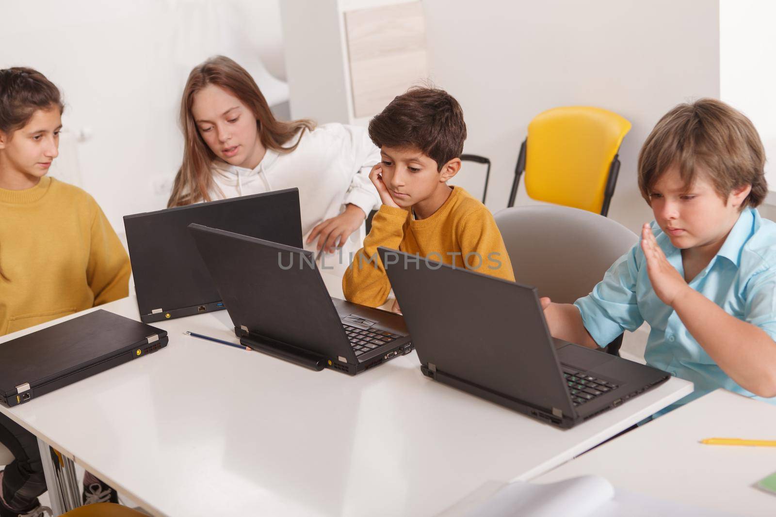 Group of kids using laptops, working on a school project