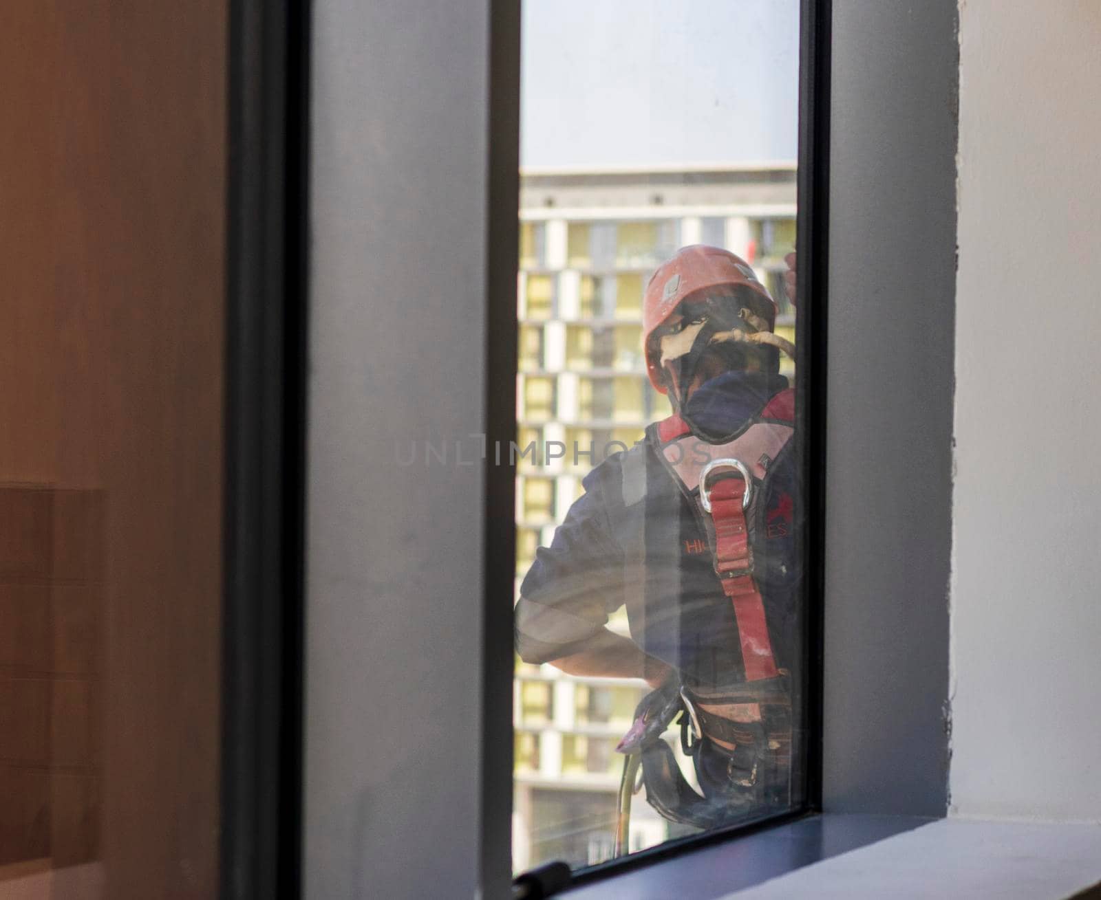 Silhouette of a rope access glass cleaner working at heights.