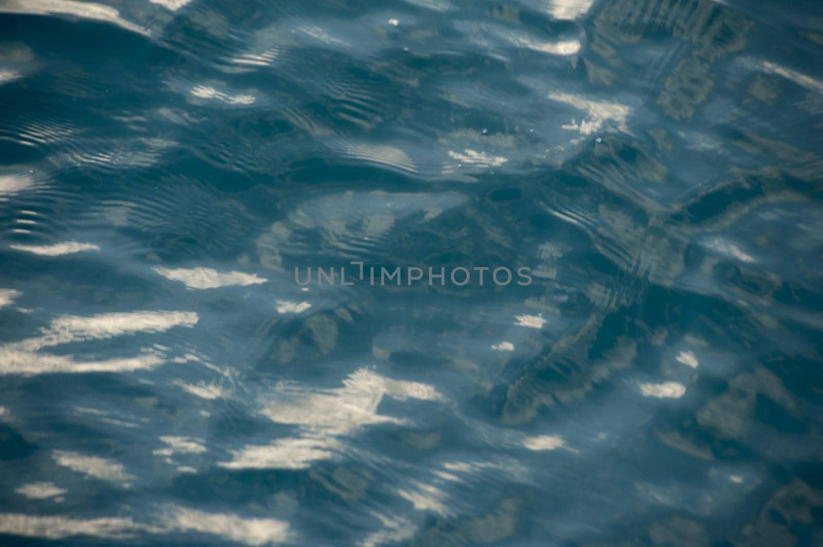 Rippling water abstract background texture with sunlight reflections in a full frame view