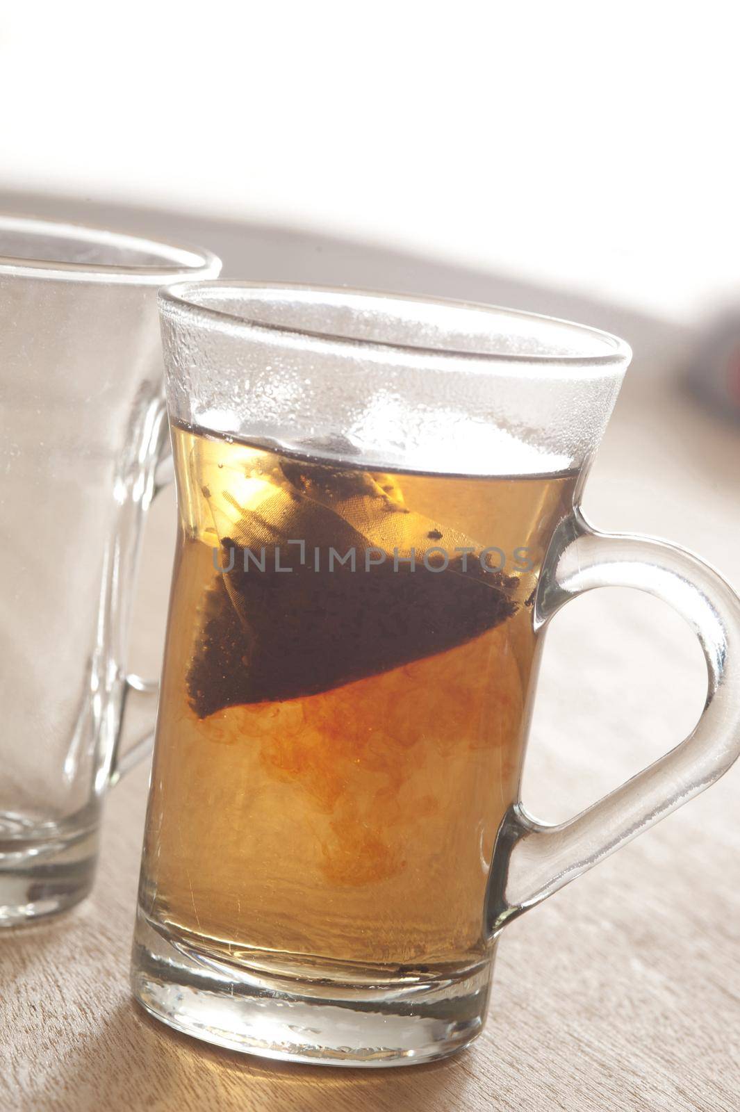 Transparent glasses with brewing hot black tea. Daylight