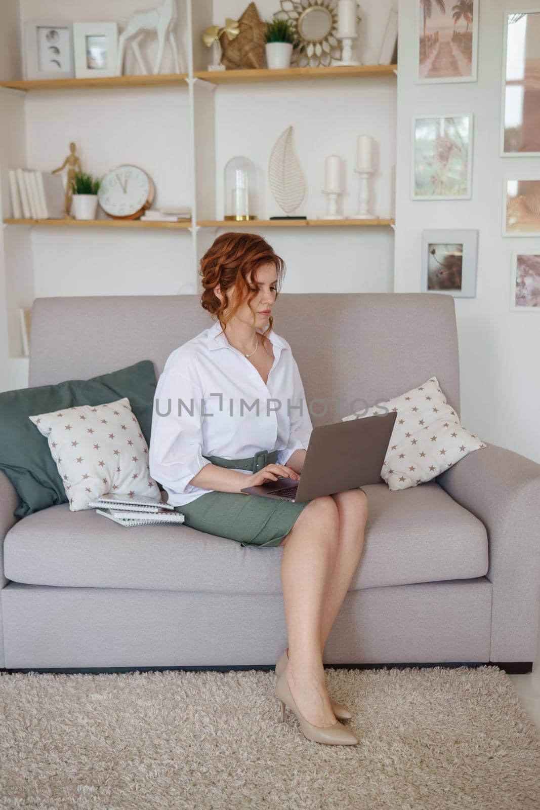 A business woman with a laptop. A human design specialist works at home on a laptop. Work from home during the epidemic.