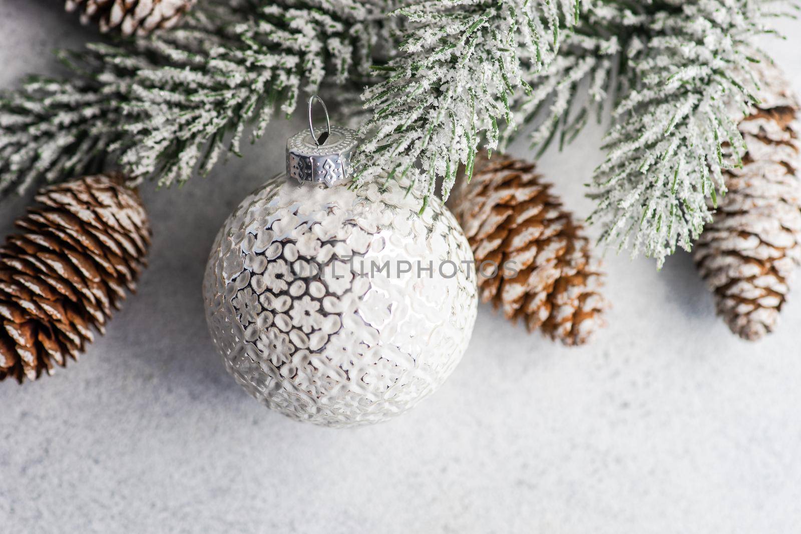 Christmas frame with pine tree, cones and ball on white rustic background