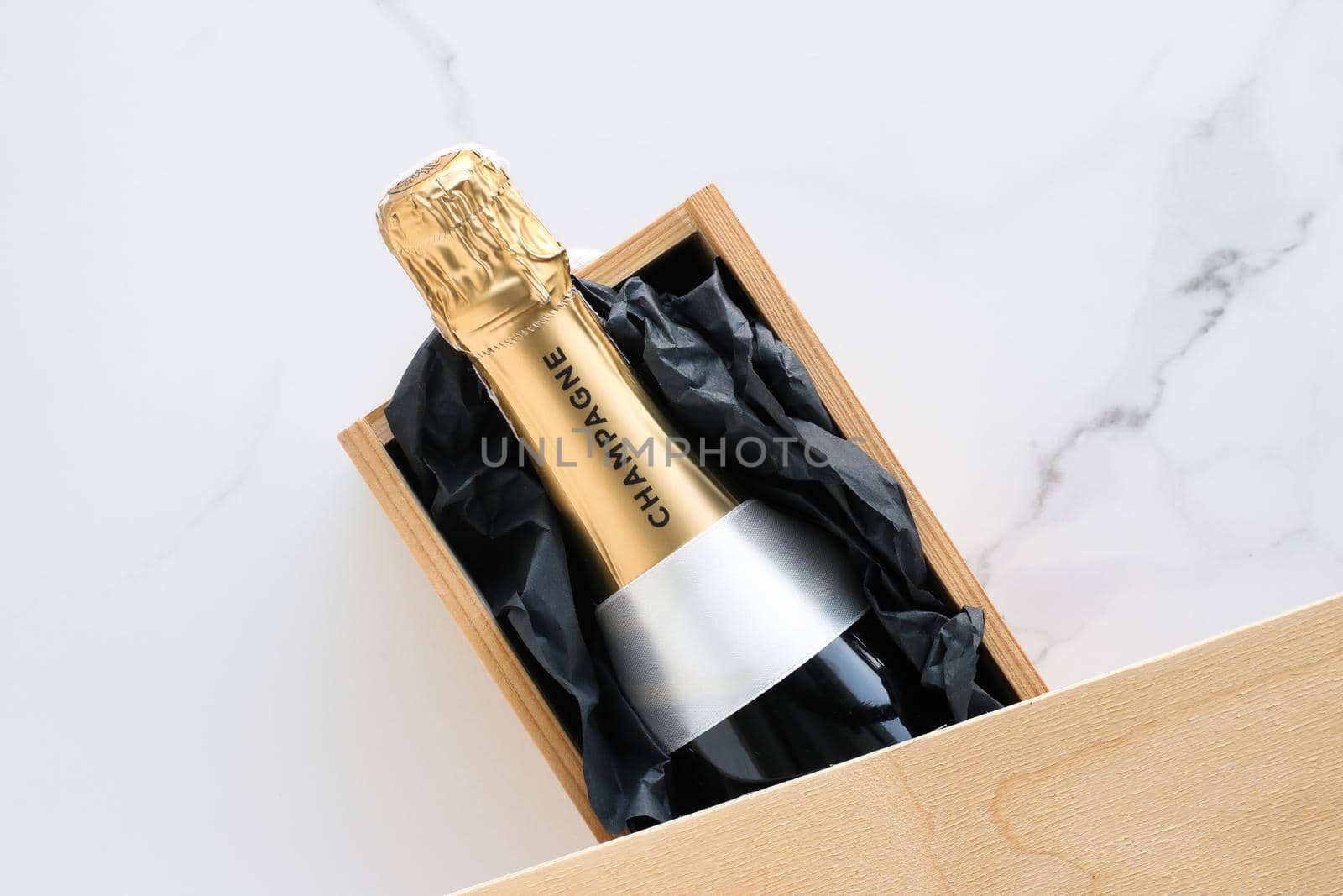 Wedding celebration, lifestyle and luxury present concept - A champagne bottle and a gift box on marble