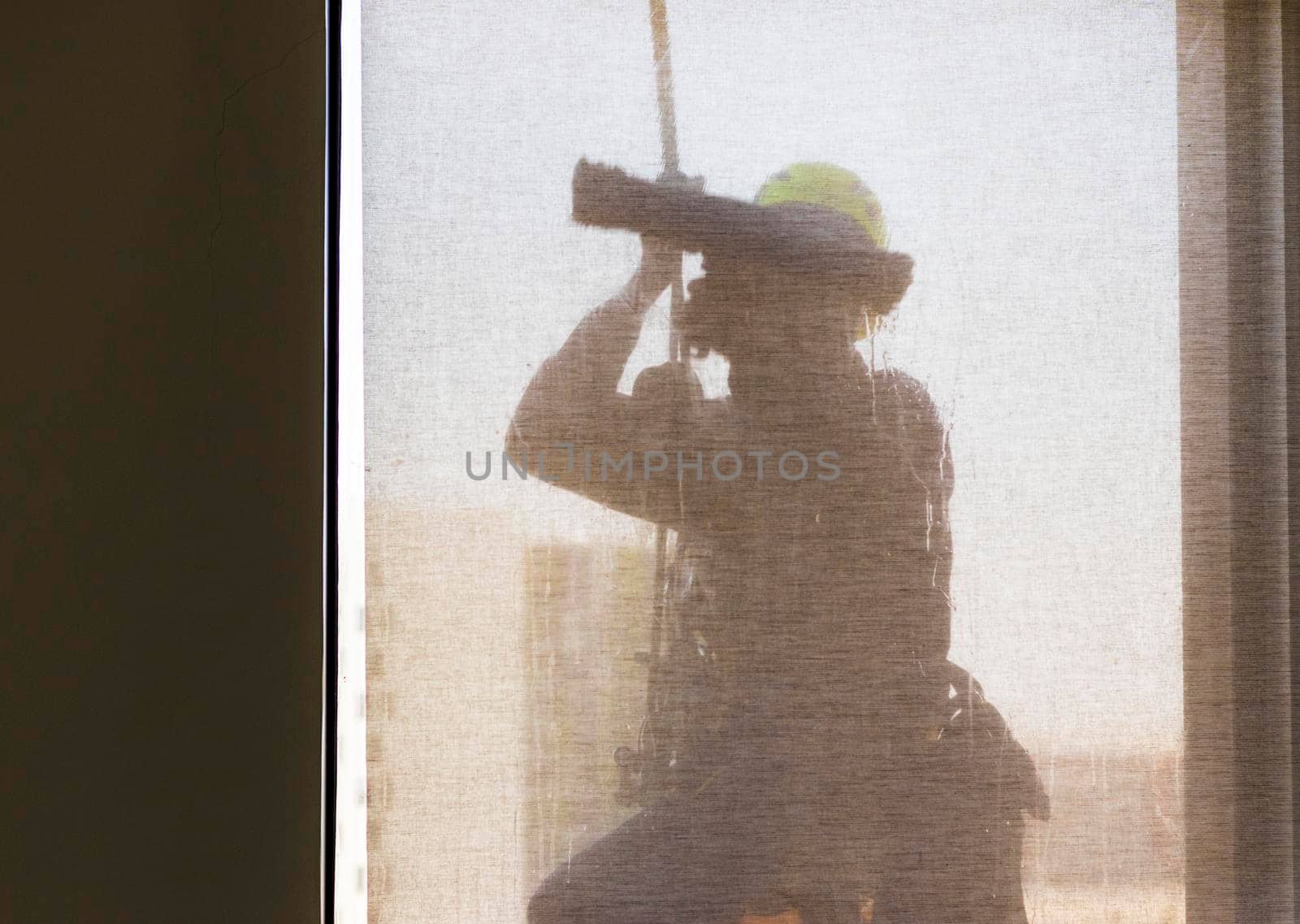 Silhouette of a rope access glass cleaner working at heights.