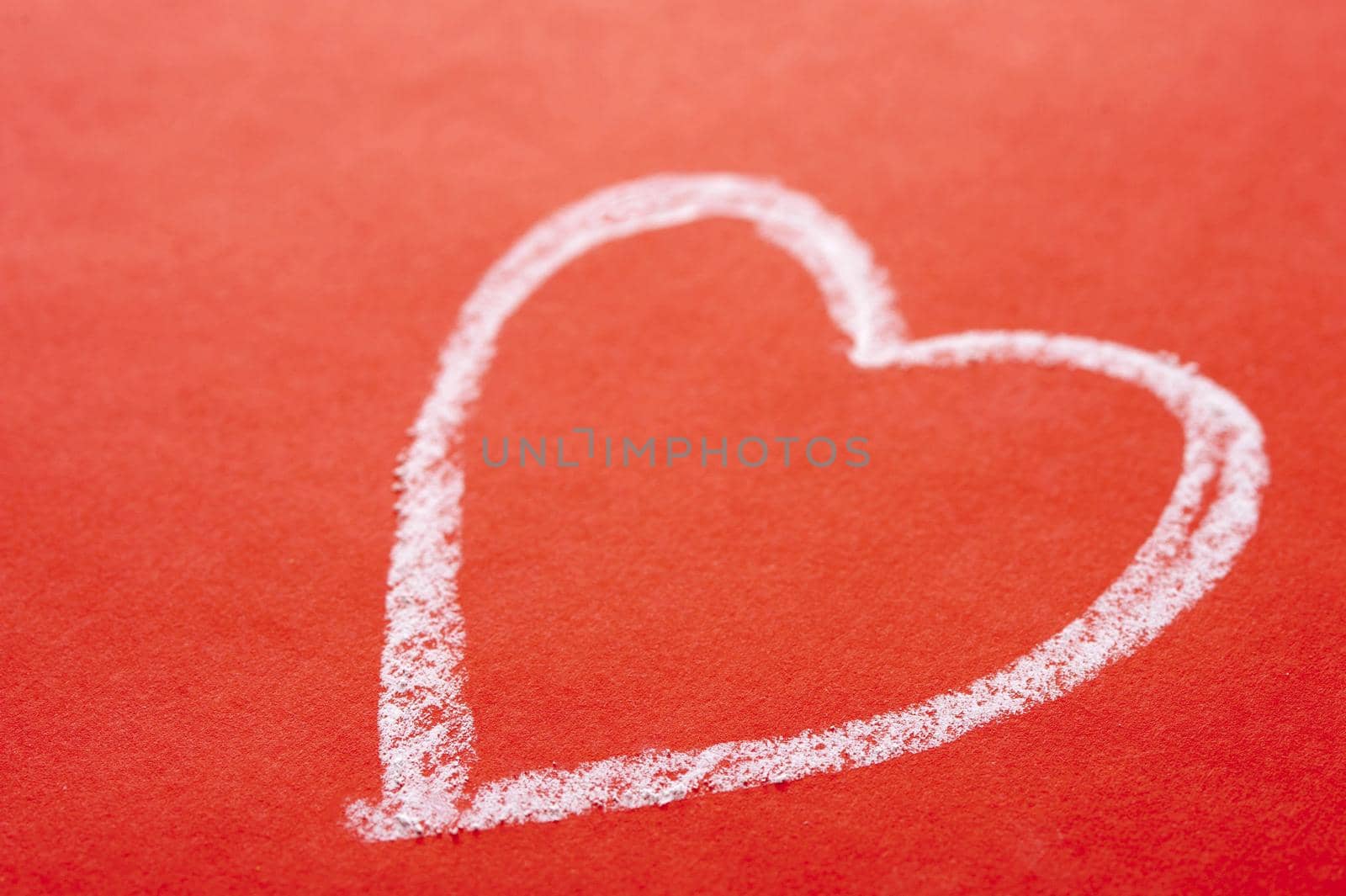 White chalk hand drawn Valentines heart on a textured red background with copyspace for a message to your sweetheart