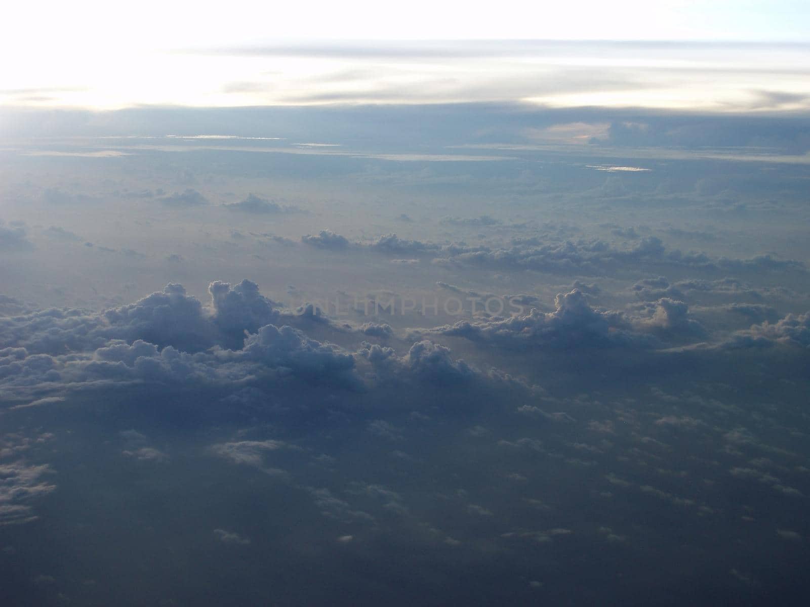 Majestic high angle view of clouds in a blue hue as seen from plane