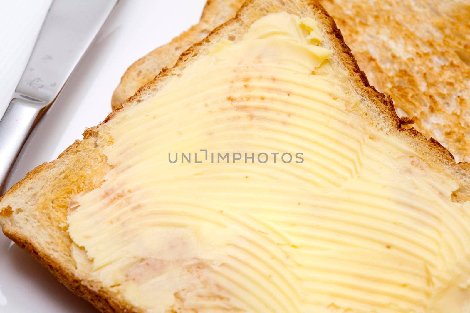 Closeup of a whole slice of buttered toast served for breakfast or as a midday snack