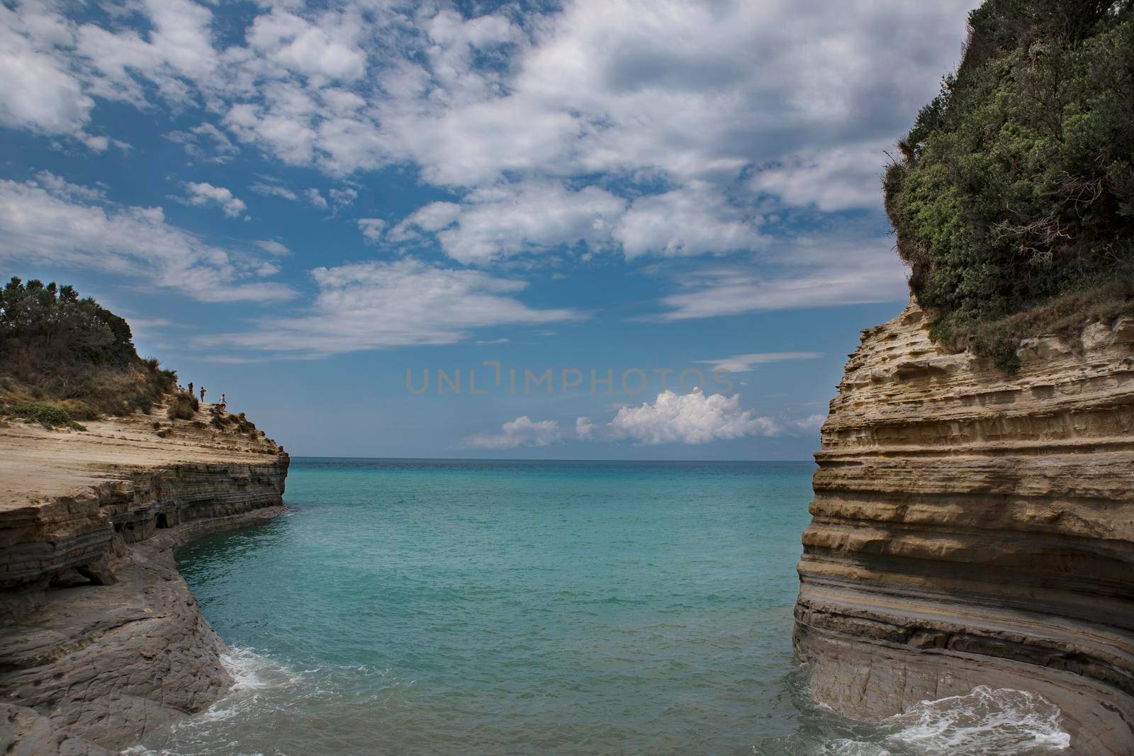 the concept of recreation and wellness for children and adults to breathe the sea air, take natural vitamin D from the sun lying under the blue sky or making a water voyage on a boat or a speedboat to enjoy the splash of waves and catch the magical shades of water in Paleokastritsa on the island of Corfu Corfu in Greece. High quality photo