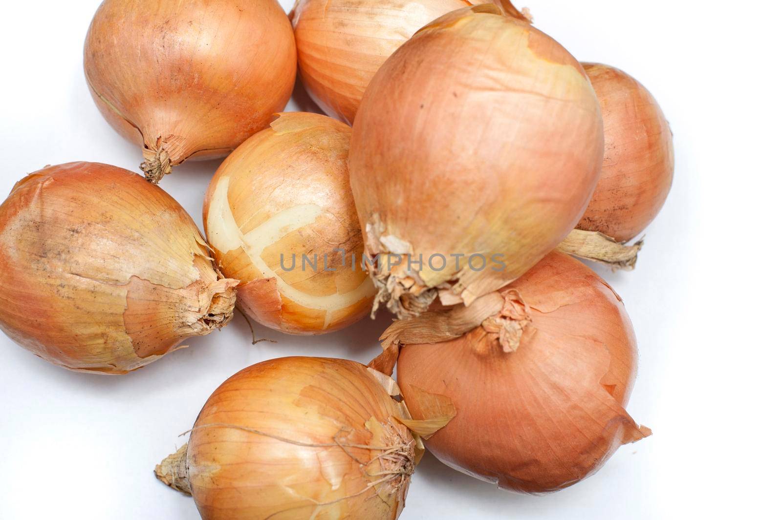 Pile of fresh whole raw brown onions, a pungent aromatic vegetable used in cooking as a flavouring