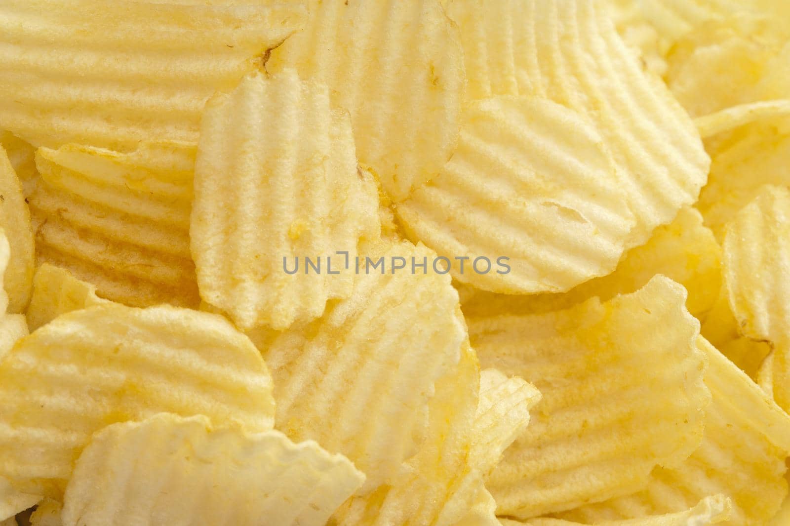 Delicious plain ruffled potato chips piled unceremoniously one atop another