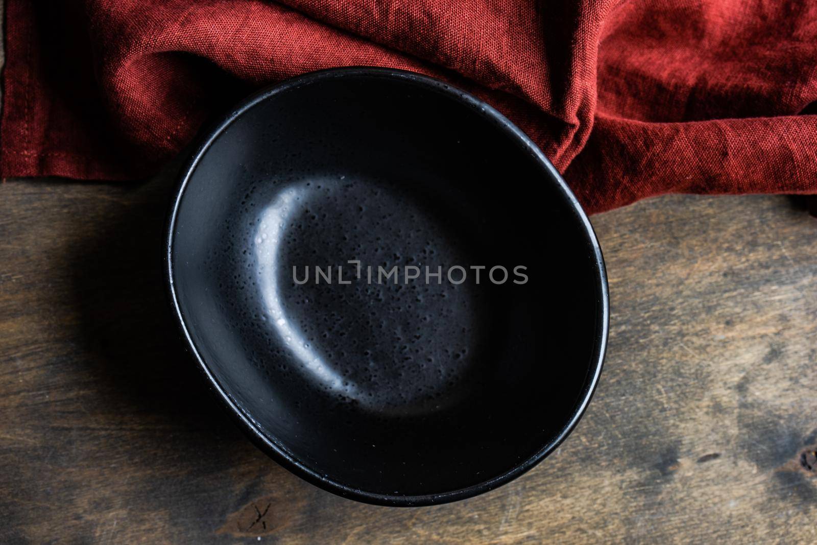 Minimalistic table setting with ceramic bowl and cutlery on wooden table