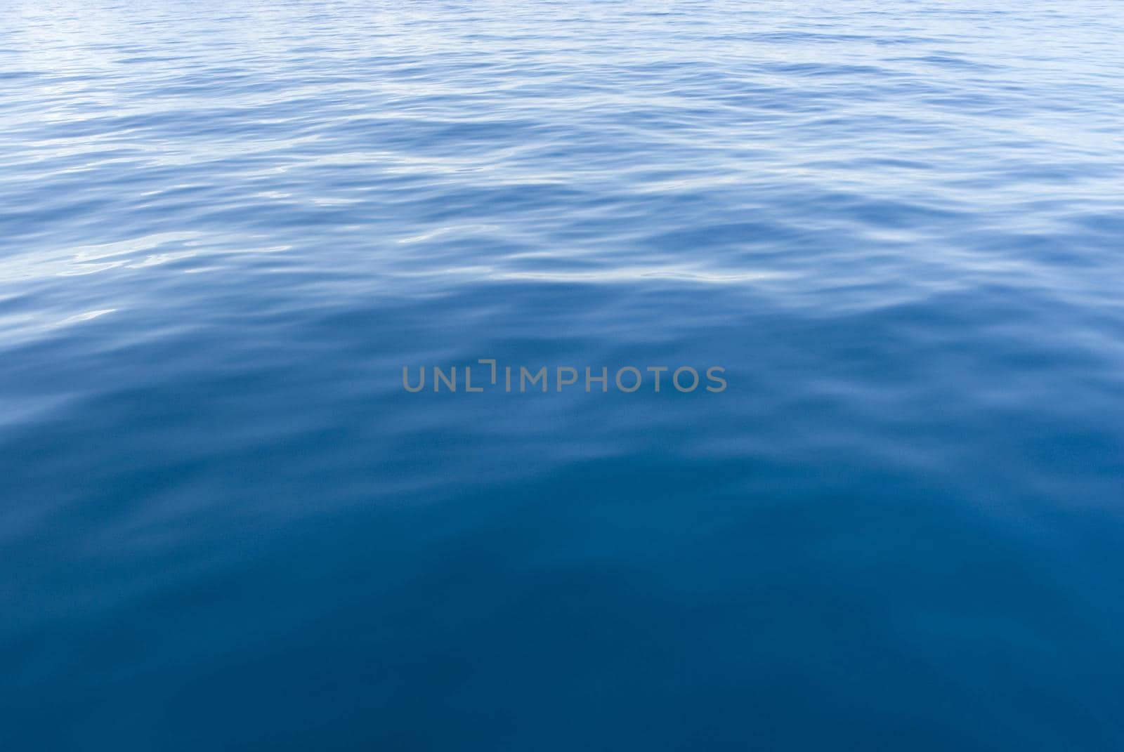 Background texture of the surface of blue sea water with ripples and reflections of sunlight for nautical or marine themed concepts