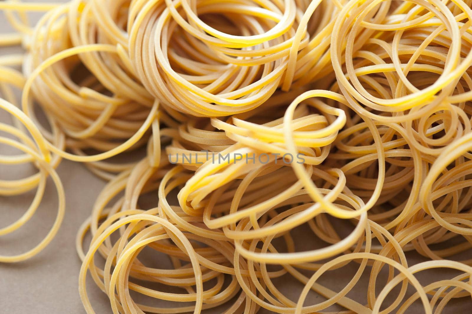 Close up Scattered Unused Yellow Elastic Rubber Bands on the Table