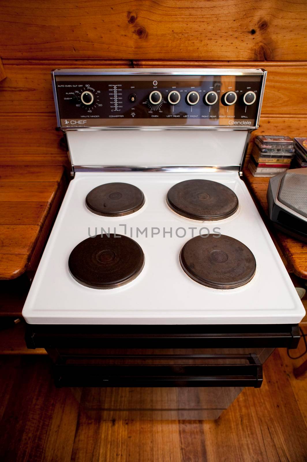 Modern domestic freestanding stove with four solid hot plates in a wooden kitchen for cooking food and household meals