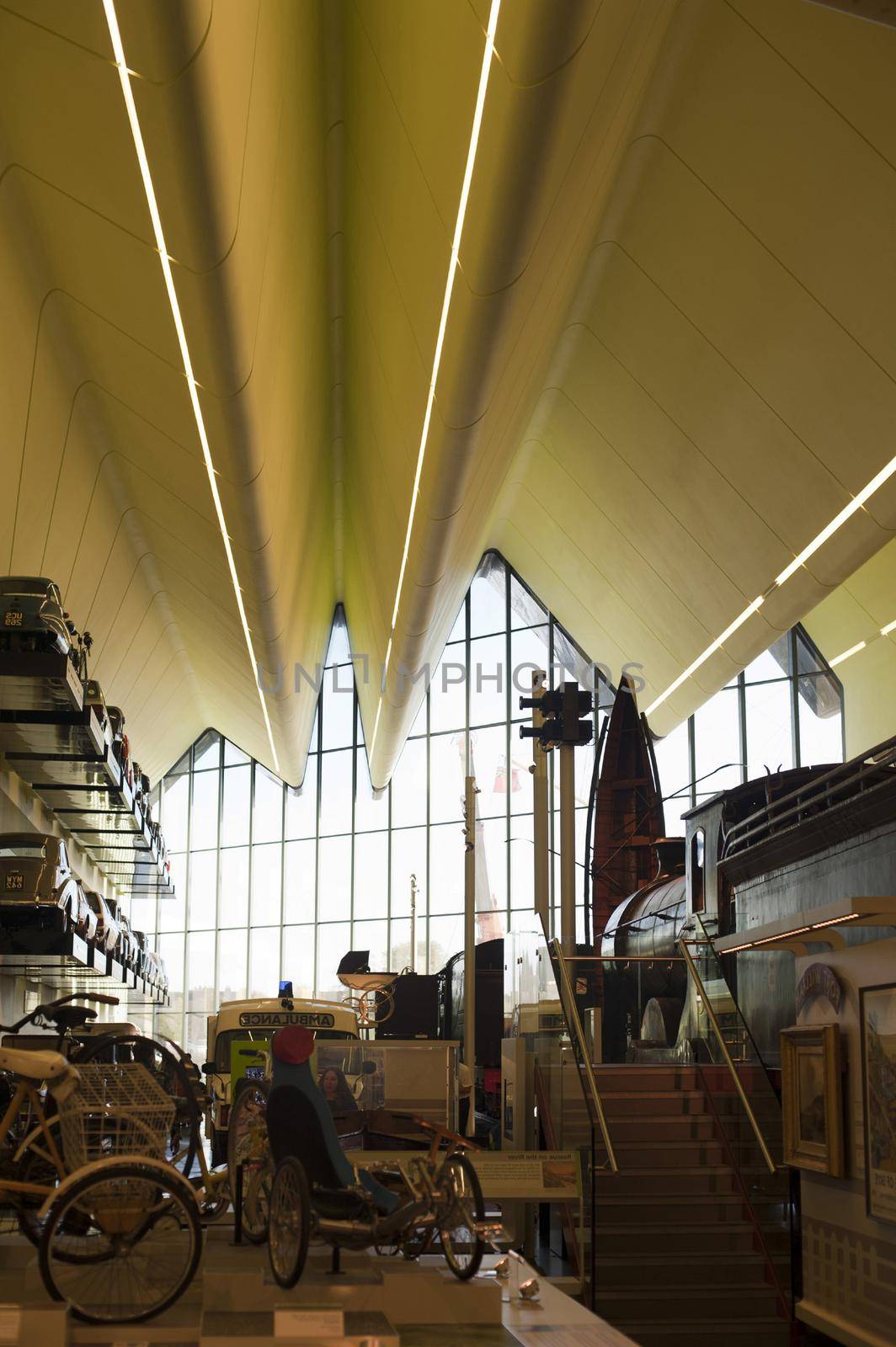 Interior of the Riverside Museum in Glasgow housing exhibits from the Museum of Transport with cars and a train on display