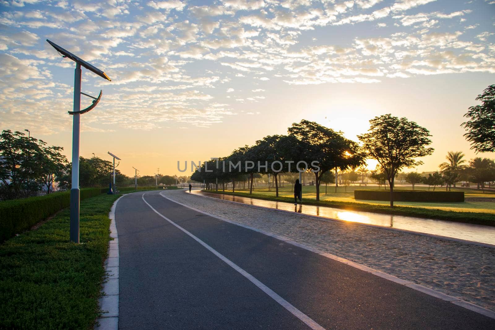 Jogging and cycling tracks in Al Warqa park, Dubai, UAE early in the morning. Lamp post powered by solar panels can be seen in the picture. Outdoors