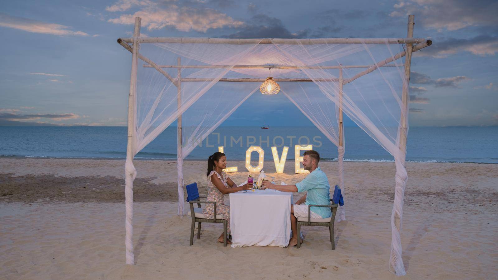 Romantic dinner on the beach of Huahin Thailand, dinner by candlelight in Hua Hin, Valentine's concept. Couple of men and women having a romantic dinner on the beach in Thailand