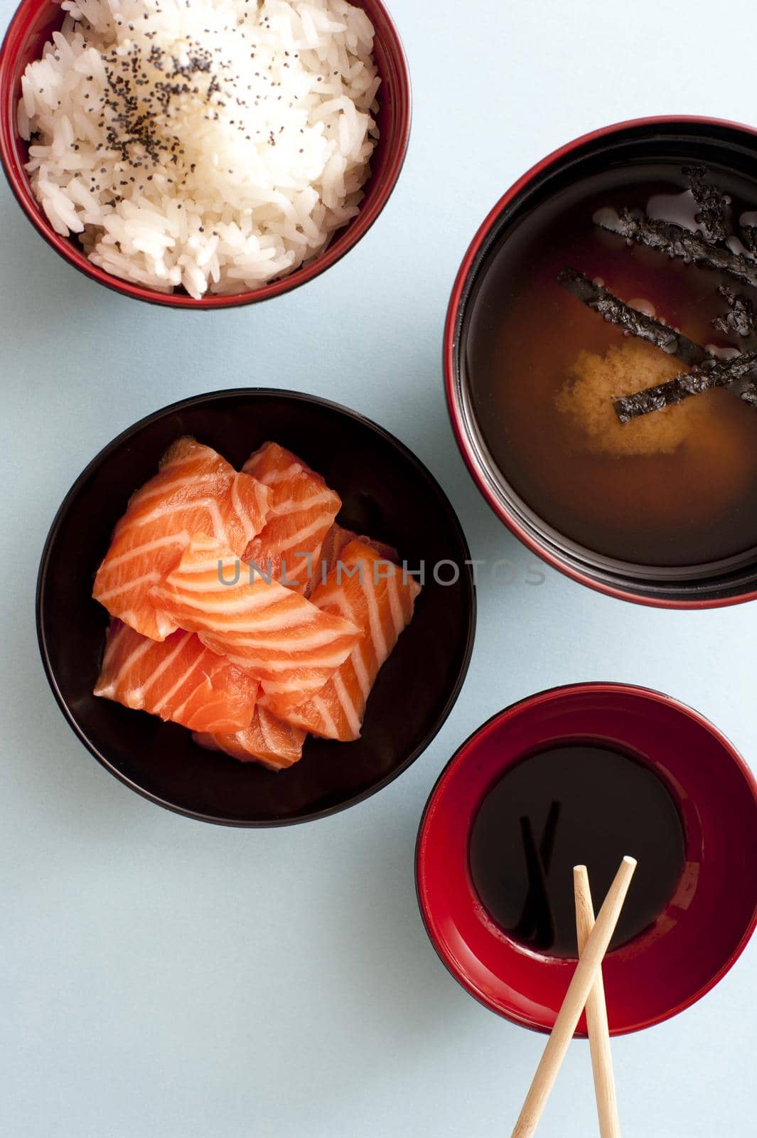 Traditional Asian sashimi with raw salmon with rice, miso and soy sauce in individual bowls , overhead view