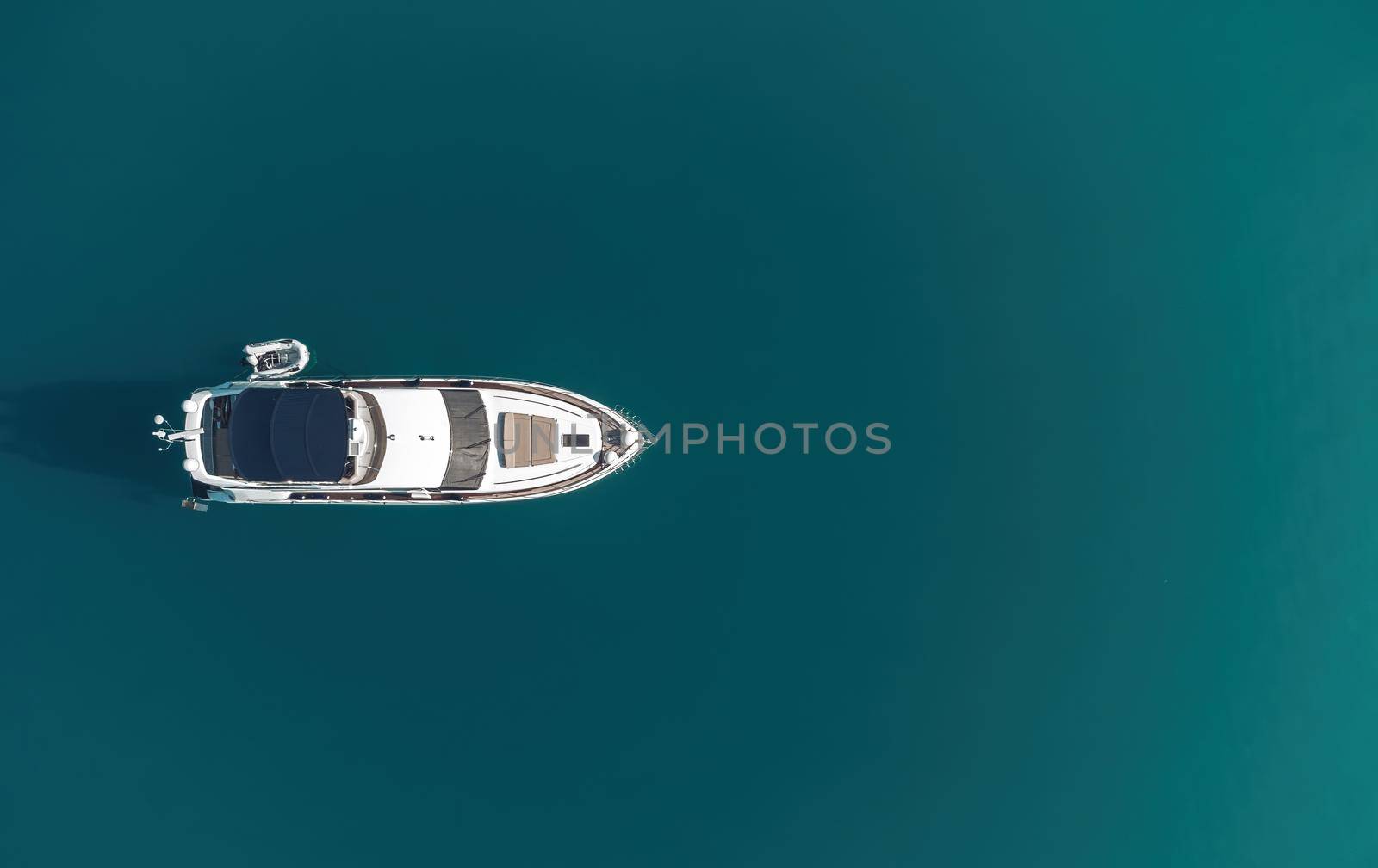 Aerial boat race. Luxury cruise trip. View from above of white boat on deep blue water. Aerial view of rich yacht sailing sea. Motor boat racing wave. Summer journey on luxury ship