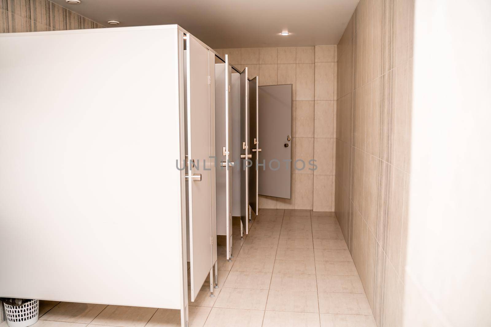 The interior of a public toilet. A number of cabins.