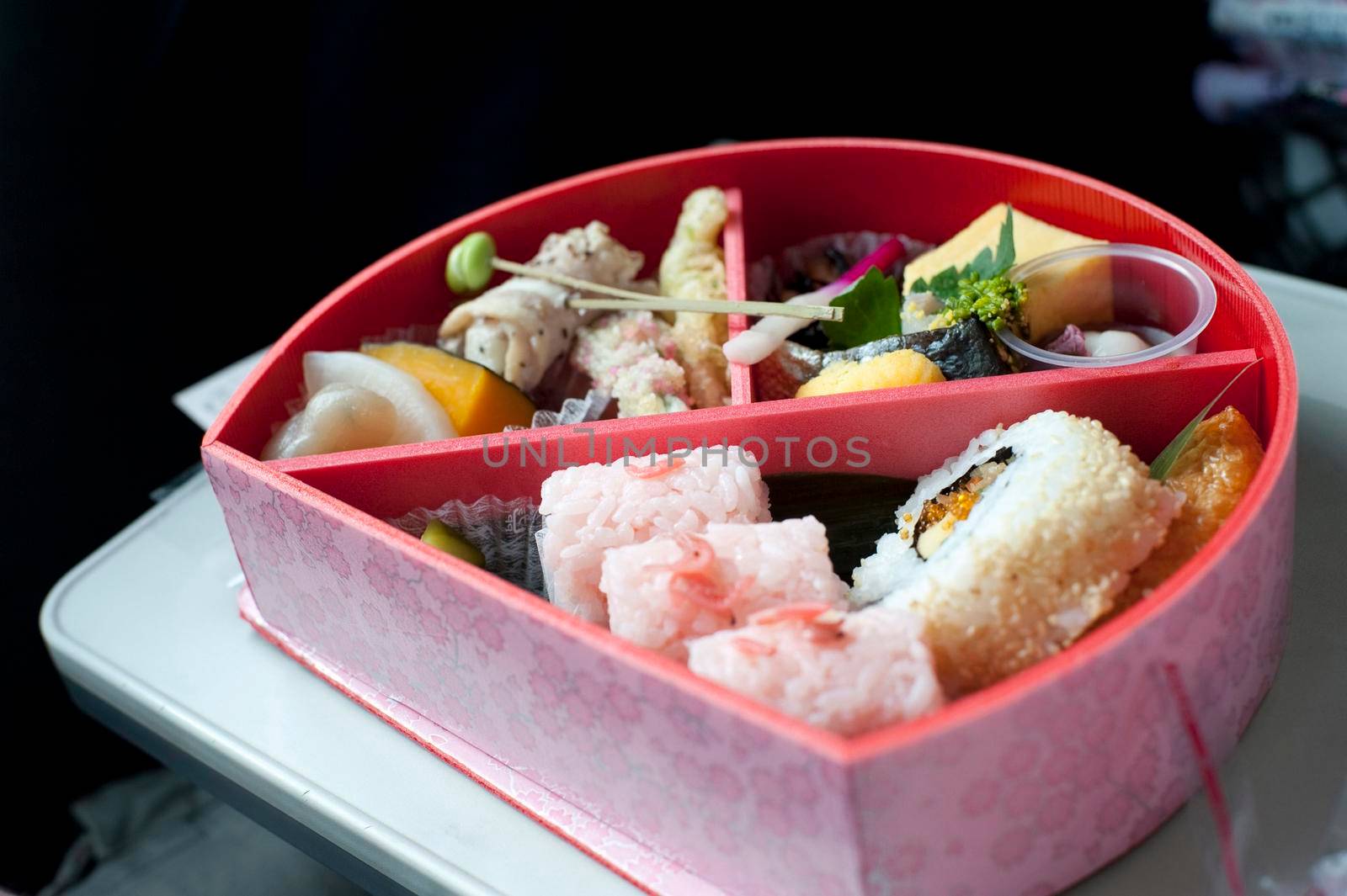 Serving of food inside a bento box, a lacquered container with internal divisions to house a complete traditional Japanese meal
