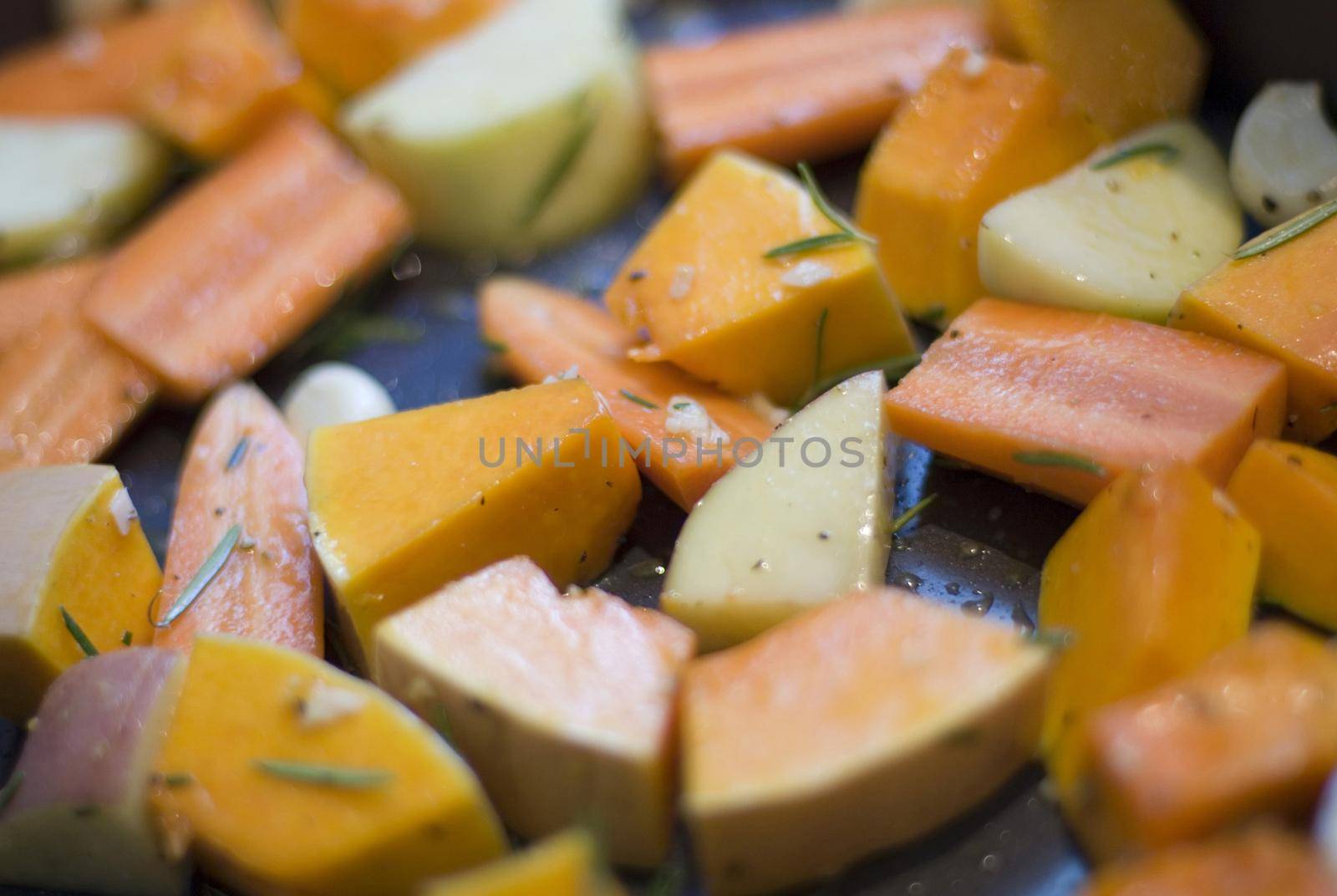 a tray of seasonal winter vegetables ready for roasting with oil and herbs