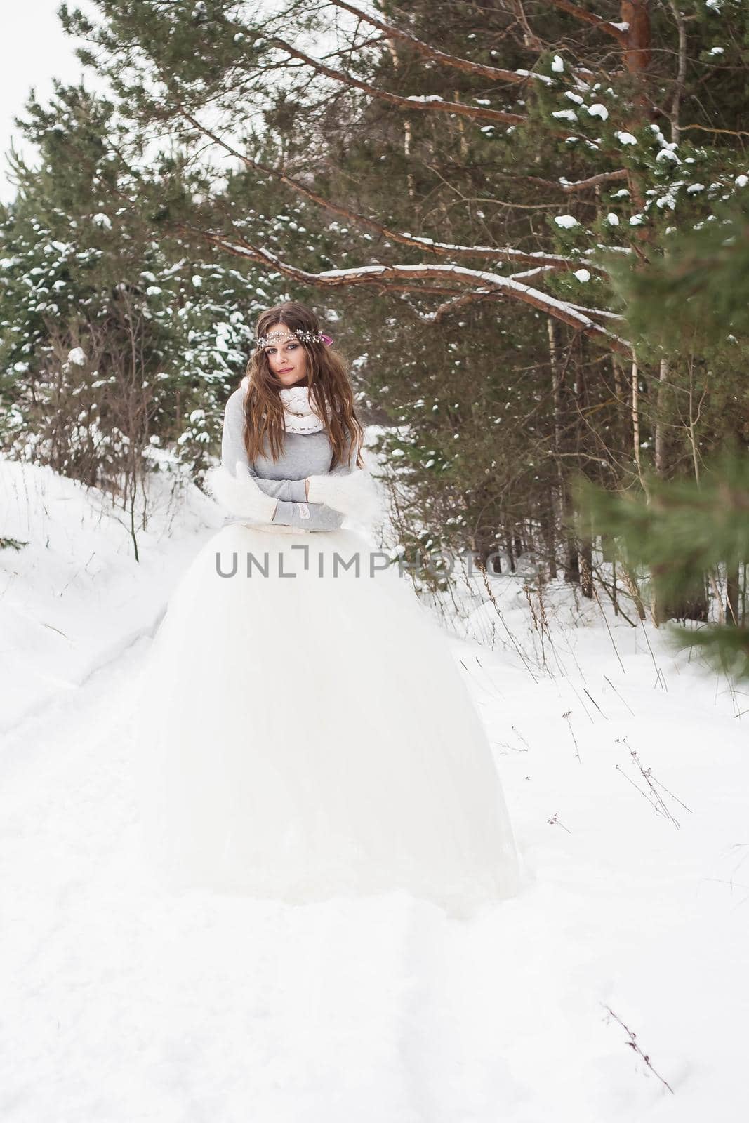 Beautiful bride in a white dress with a bouquet in a snow-covered winter forest. Portrait of the bride in nature by Annu1tochka
