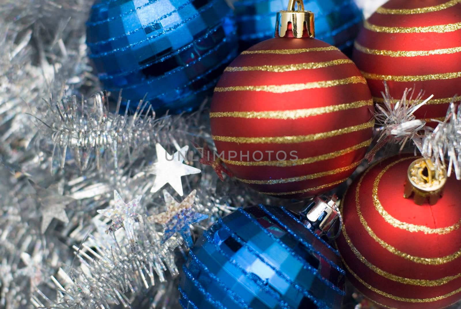 an assortment of reflective christmas baubles on a background of silver tinsel