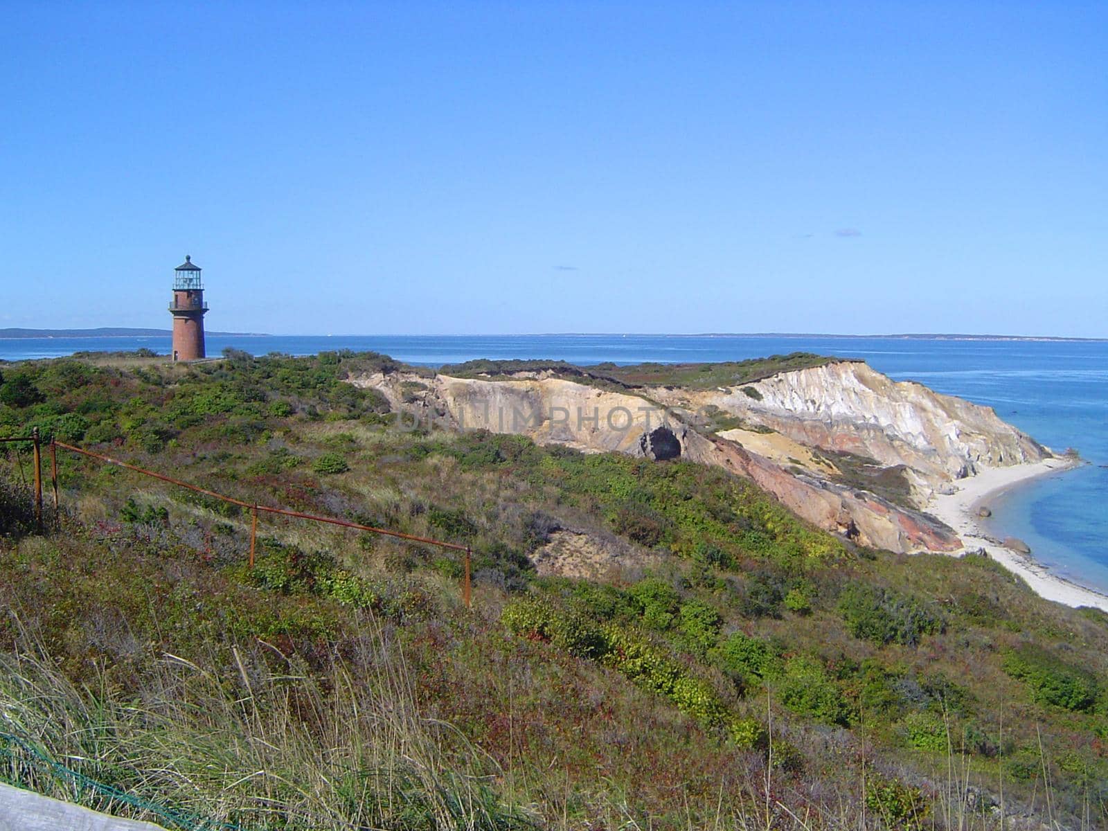 a small lighthouse atop of colored chalk cliffs