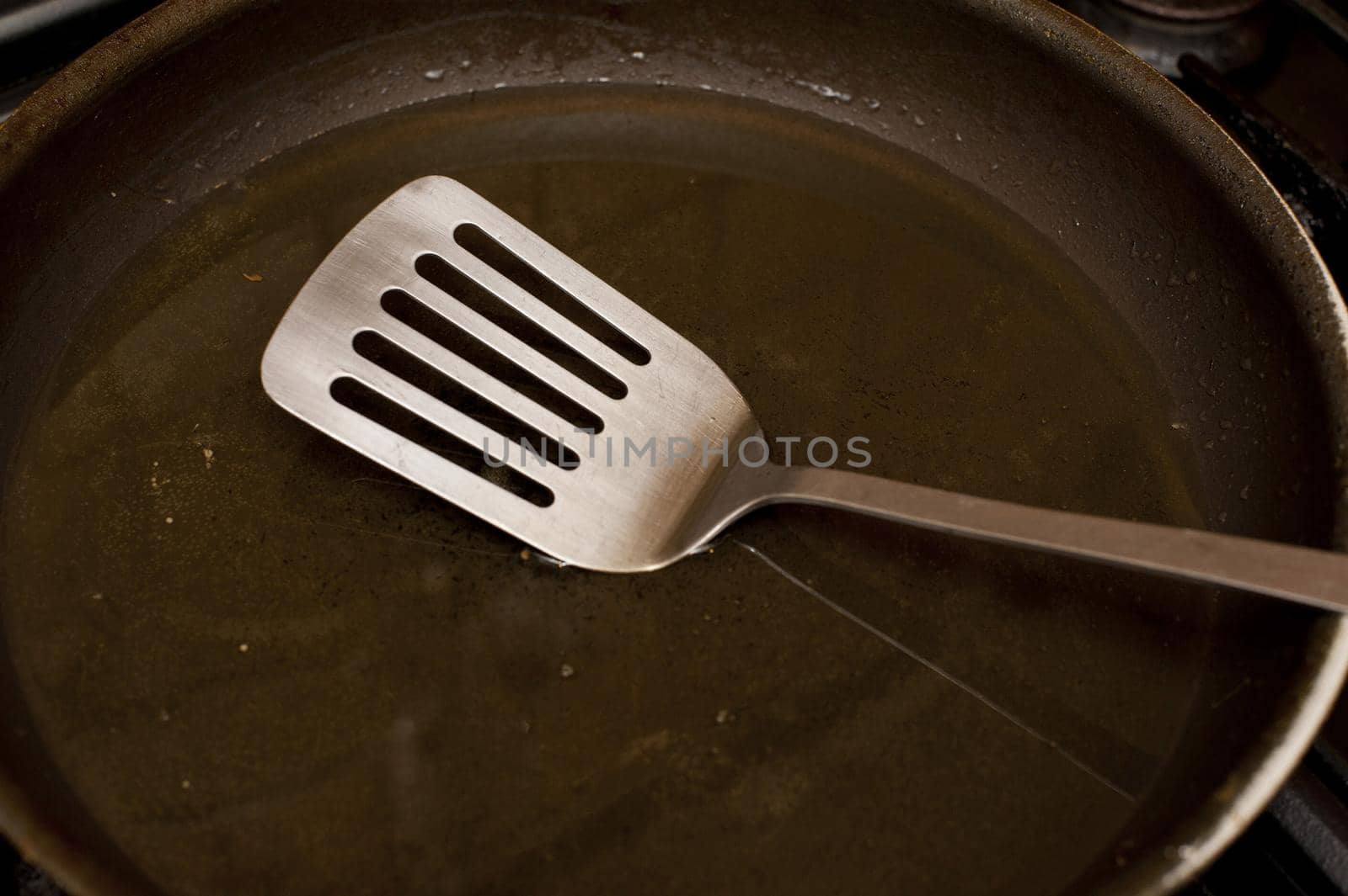 Clean non-stick frying pan with metal spatula in a close up view in a food cooking concept