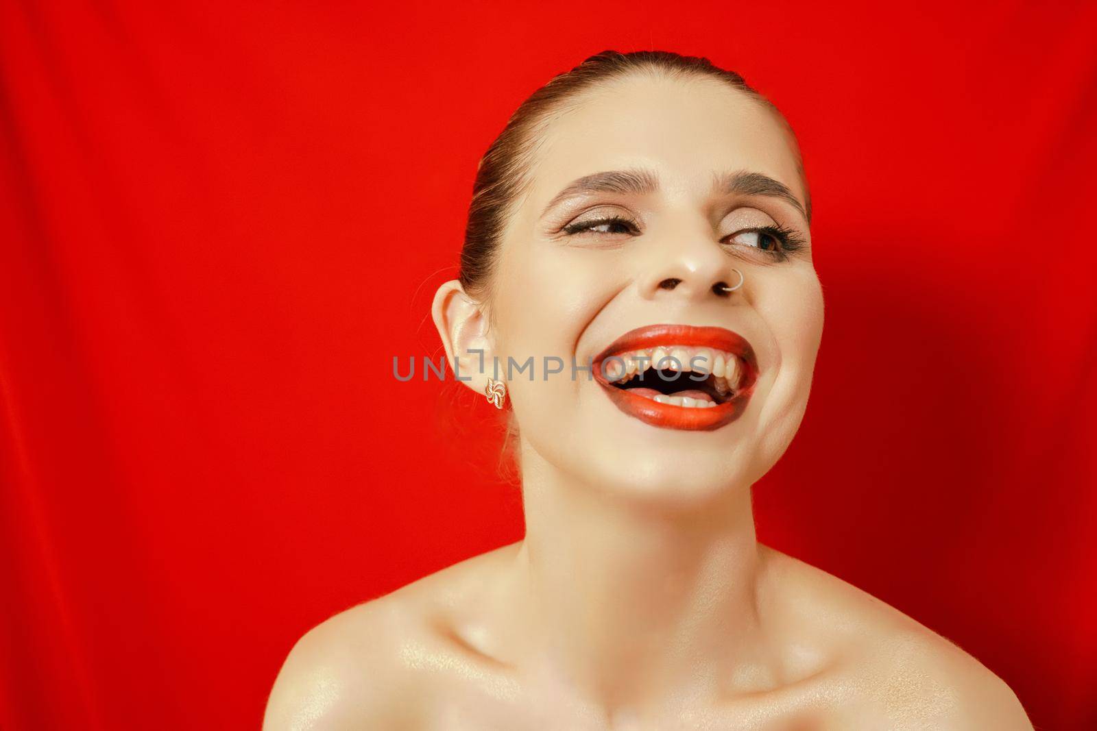 Portrait of a smiling beautiful young woman. Red background. Studio shot