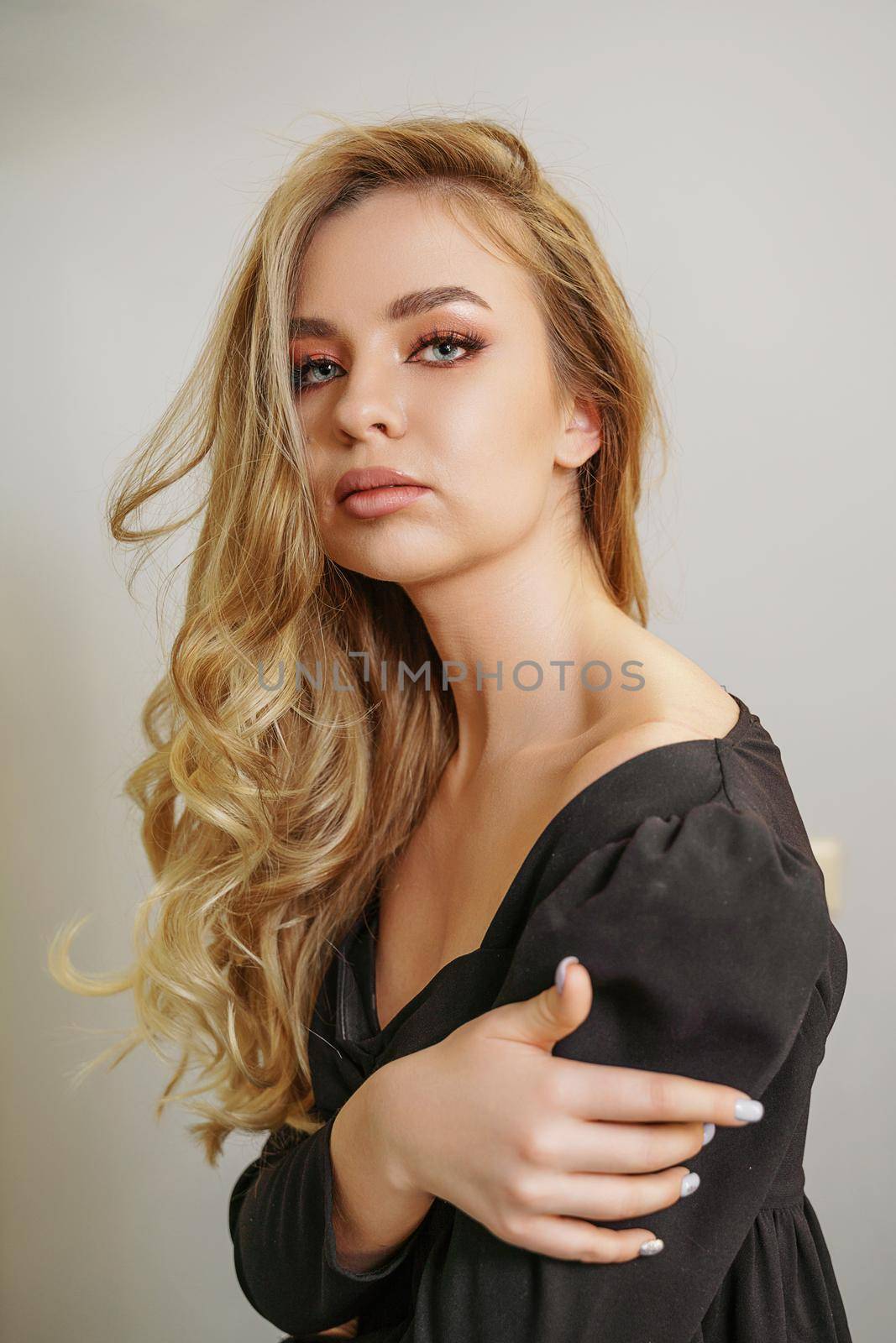 Beautiful young blonde woman face closeup portrait in studio on a light background.