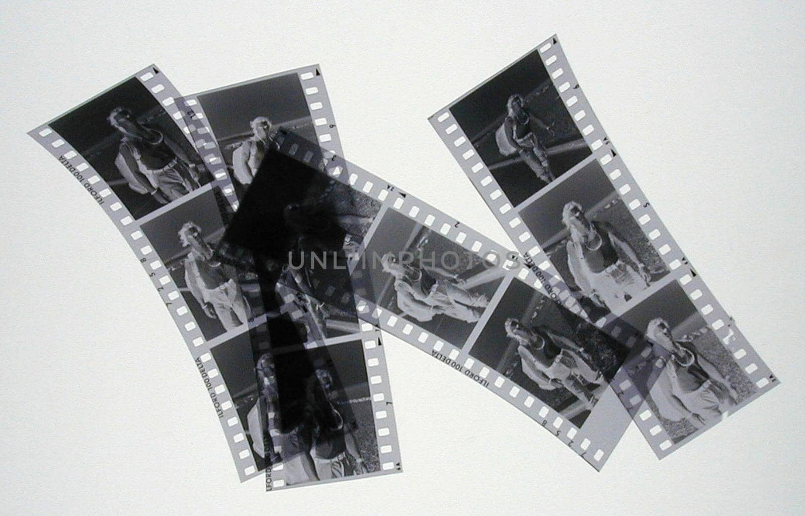 Four strips of negatives cut into three sections over gray background or light table