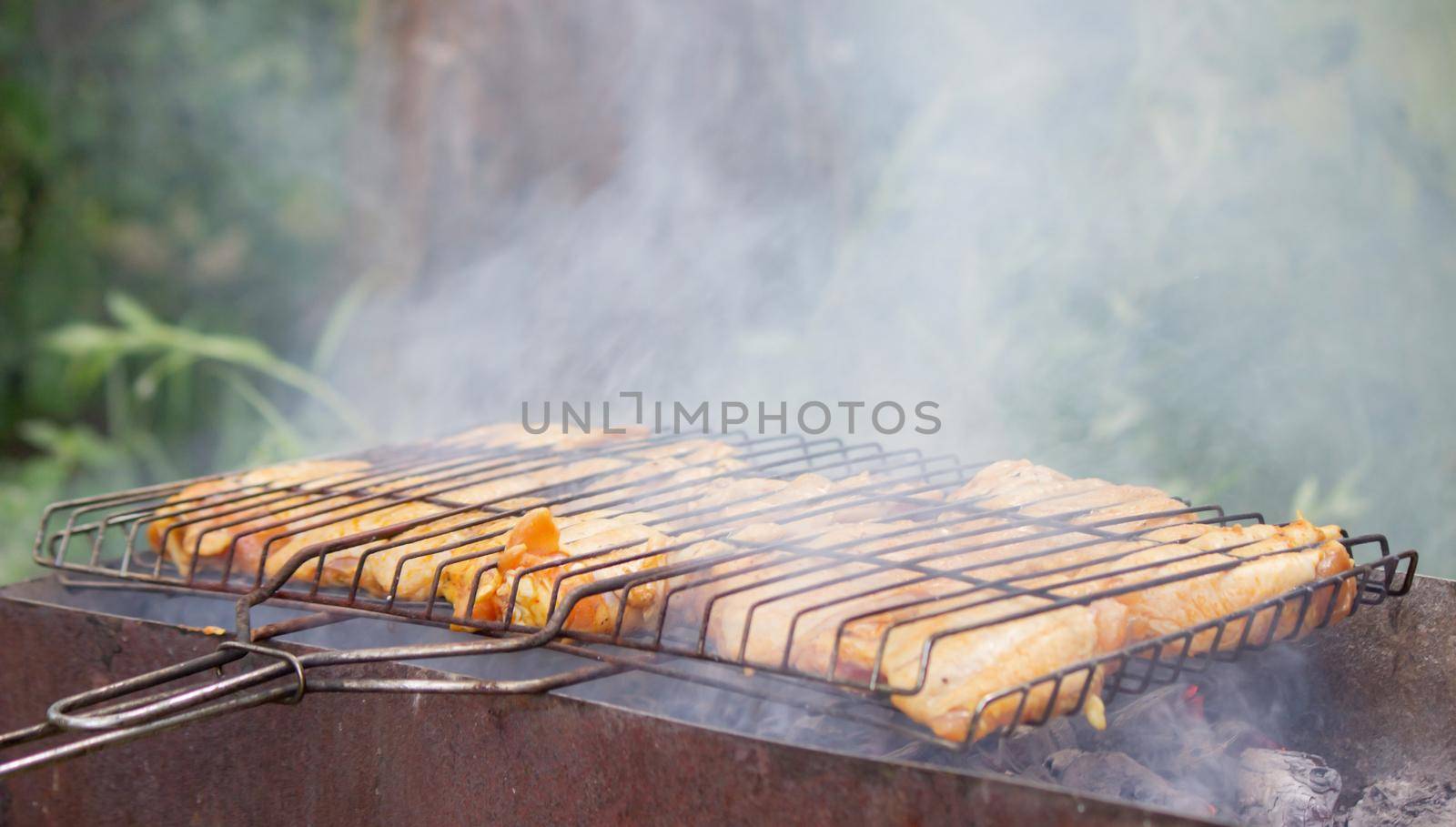 fry chicken skewers on the grill. Picnic in nature. selective focus